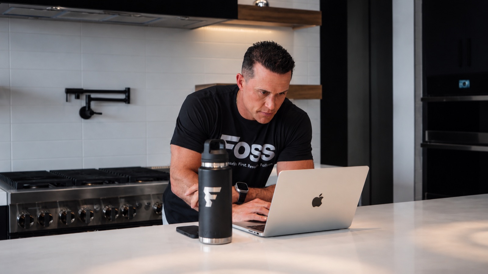 Matt Foss at the kitchen counter, checking the business from a laptop